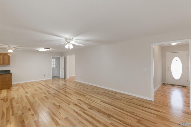 unfurnished living room featuring ceiling fan and light wood-type flooring