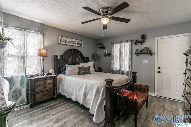 bedroom with baseboards, a textured ceiling, wood finished floors, and a ceiling fan