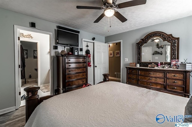 bedroom featuring wood finished floors, baseboards, ceiling fan, and a textured ceiling