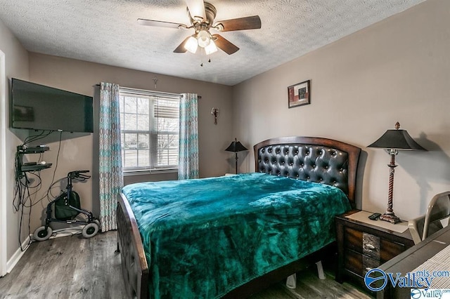 bedroom with a ceiling fan, wood finished floors, and a textured ceiling