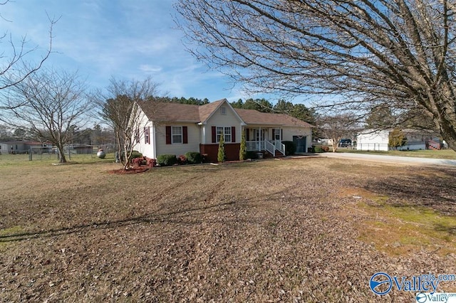 single story home featuring a front yard, an attached garage, and a porch