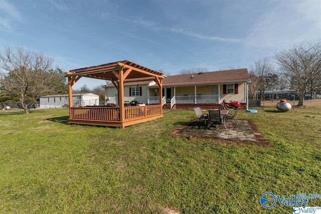 rear view of house featuring a wooden deck and a yard