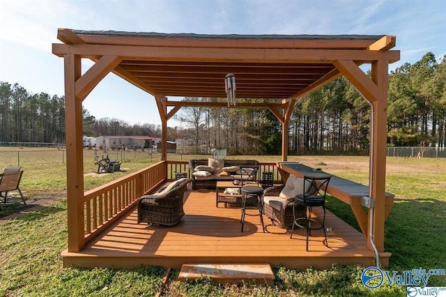 wooden terrace featuring outdoor lounge area, a gazebo, fence, and a lawn