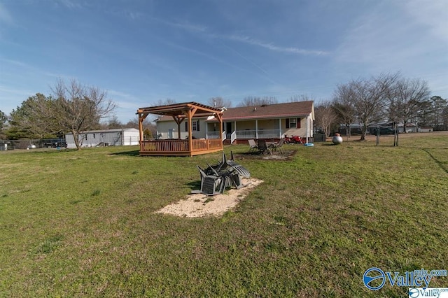 rear view of property with a yard, a pergola, and a deck