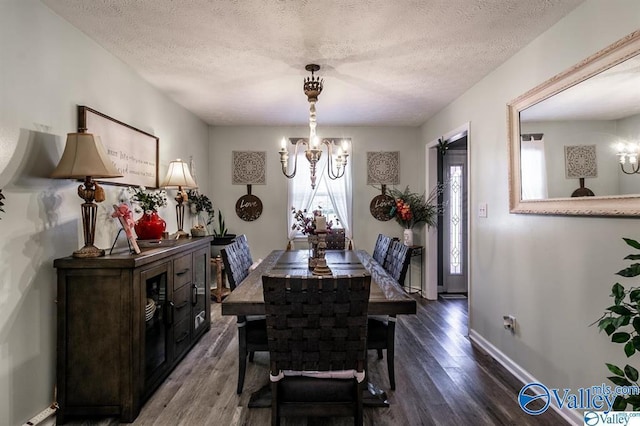 dining area with an inviting chandelier, a textured ceiling, baseboards, and wood finished floors