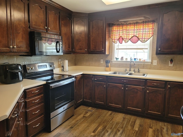 kitchen featuring stainless steel range with electric stovetop, dark brown cabinetry, dark hardwood / wood-style flooring, and sink