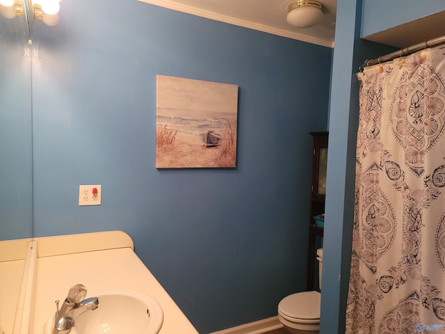 bathroom featuring sink, crown molding, and toilet