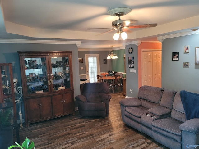 living room featuring a tray ceiling, ceiling fan with notable chandelier, crown molding, and dark hardwood / wood-style floors