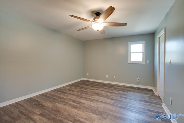 spare room with dark hardwood / wood-style floors and ceiling fan