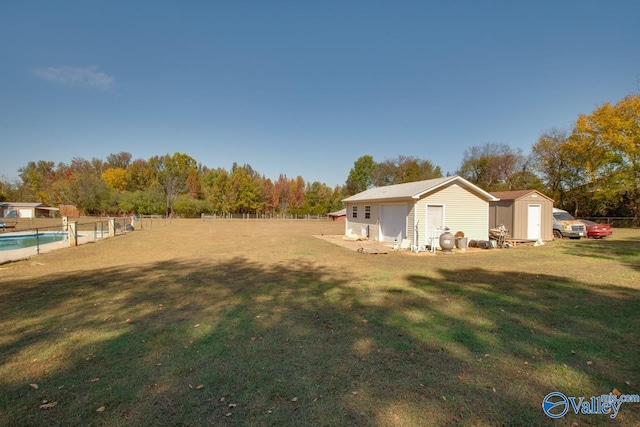 view of yard with a storage shed and a fenced in pool