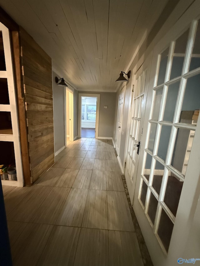 hall featuring wood ceiling and wood walls