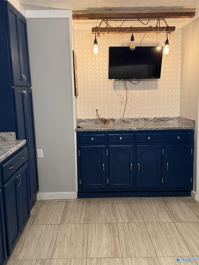 kitchen with blue cabinets, baseboards, and beam ceiling