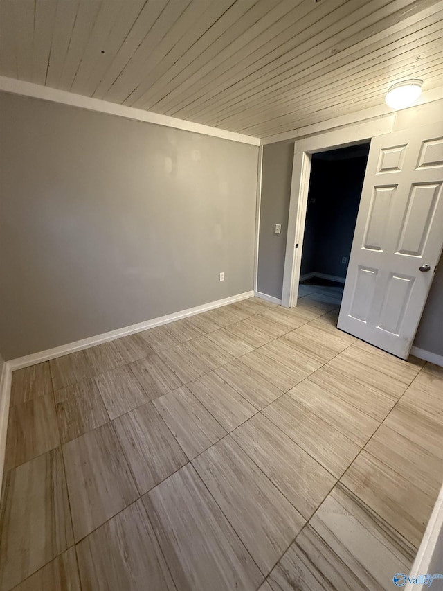 unfurnished room with wood ceiling and baseboards