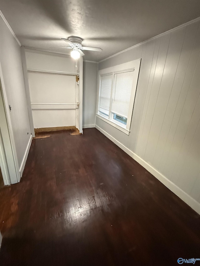 interior space with ceiling fan, baseboards, wood finished floors, and crown molding