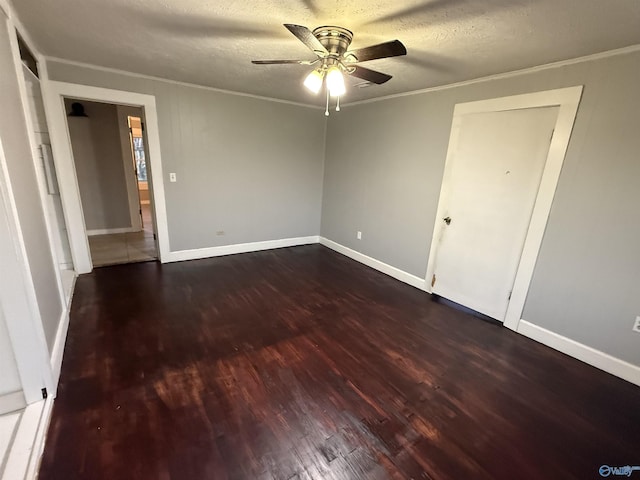 empty room featuring a textured ceiling, wood finished floors, and ornamental molding