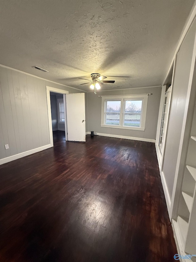 interior space featuring dark wood finished floors, baseboards, a textured ceiling, and a ceiling fan