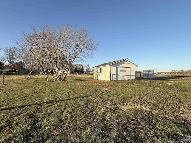 view of yard featuring an outbuilding, a rural view, and fence