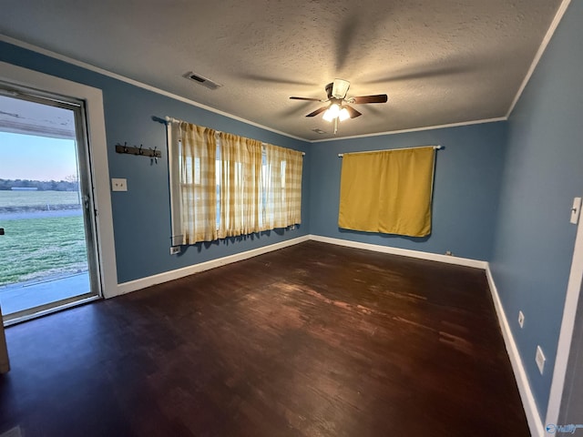 spare room featuring wood finished floors, baseboards, ceiling fan, ornamental molding, and a textured ceiling