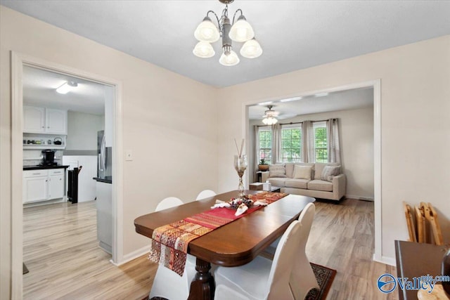 6304 Cedar Point Dr, Huntsville, AL 35810 - dining space featuring light wood-style flooring, a chandelier, baseboards, and a ceiling fan