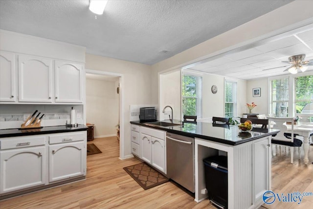 6304 Cedar Point Dr, Huntsville, AL 35810 - kitchen with stainless steel dishwasher, dark countertops, a sink, a peninsula, and a textured ceiling