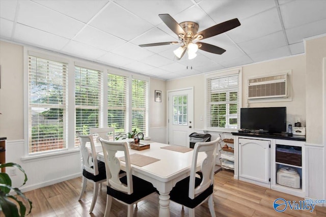 6304 Cedar Point Dr, Huntsville, AL 35810 - dining room featuring an AC wall unit, light wood finished floors, a drop ceiling, a ceiling fan, and wainscoting