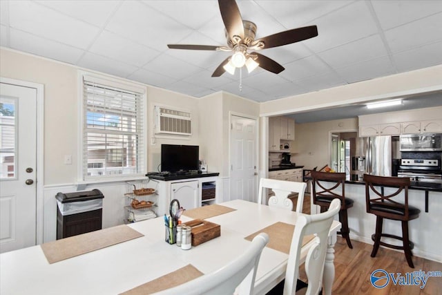 6304 Cedar Point Dr, Huntsville, AL 35810 - dining area with an AC wall unit, ceiling fan, wood finished floors, and a drop ceiling