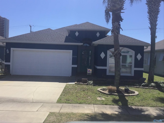 view of front facade with a front yard, an attached garage, driveway, and roof with shingles