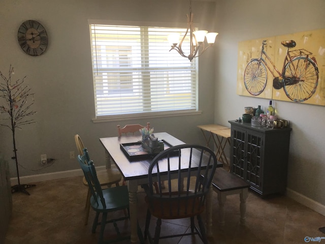 dining area featuring baseboards and a chandelier