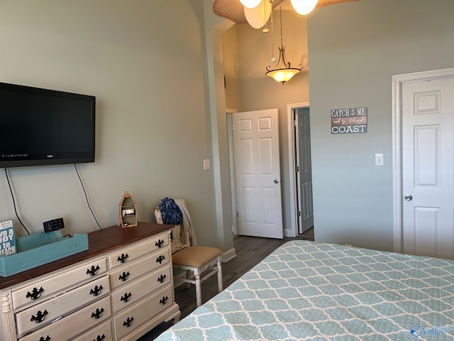 bedroom with dark wood-style flooring and a towering ceiling