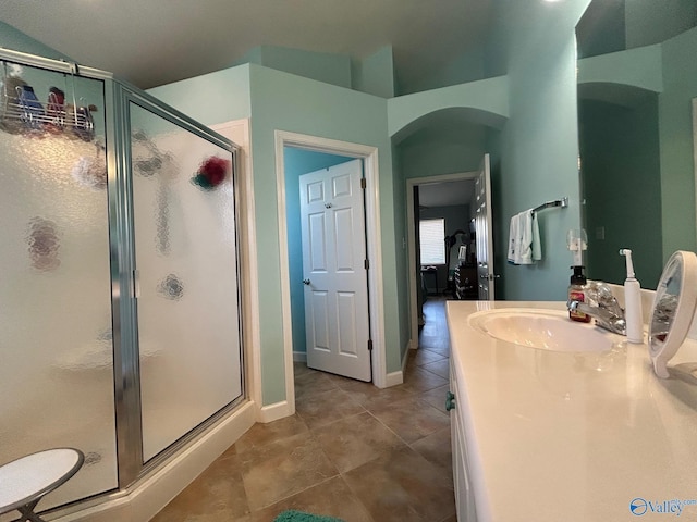 full bath featuring tile patterned floors, baseboards, a stall shower, and vanity