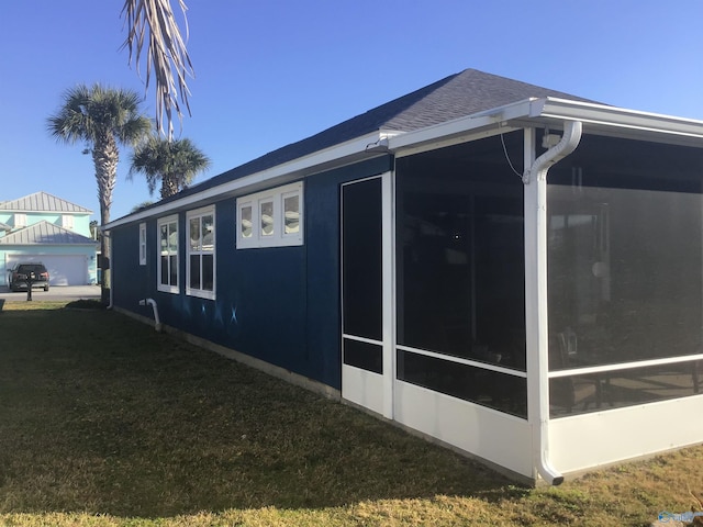 view of side of home with a lawn and a sunroom