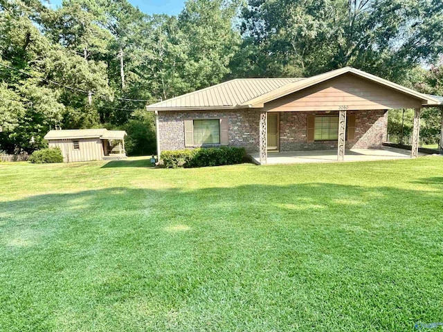 view of front facade with a patio, a front lawn, and a storage shed