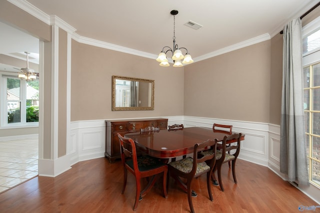 dining space with a wealth of natural light, hardwood / wood-style floors, and crown molding