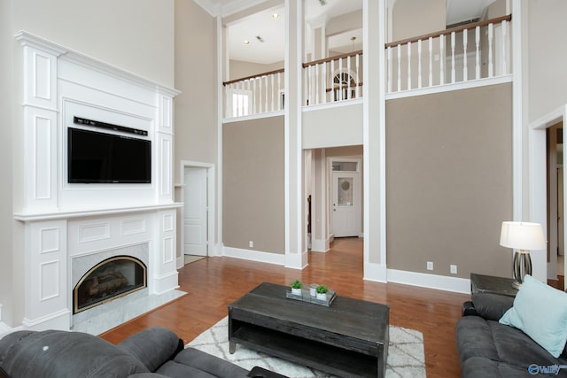 living room with a high ceiling, hardwood / wood-style floors, and a fireplace