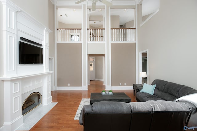 living room featuring crown molding, high vaulted ceiling, ceiling fan, and light wood-type flooring