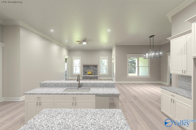 kitchen featuring dishwasher, light stone counters, white cabinetry, and sink