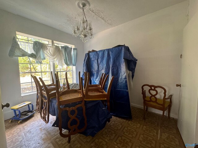 dining room with a textured ceiling and a chandelier