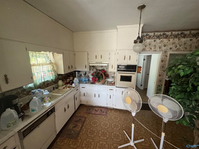 kitchen with white cabinets, white appliances, hanging light fixtures, and sink