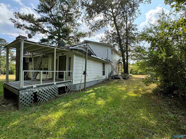 view of side of property with a lawn and a deck