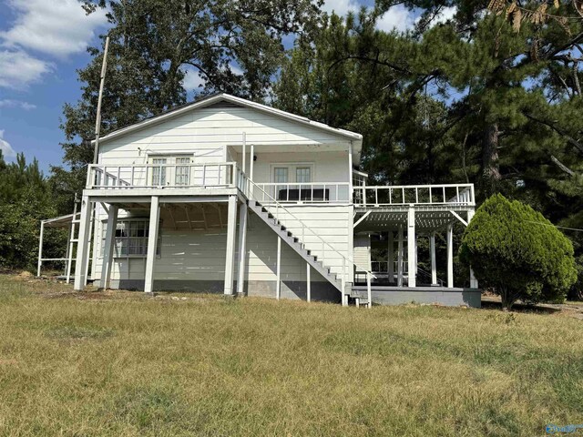 back of property featuring a lawn and a wooden deck