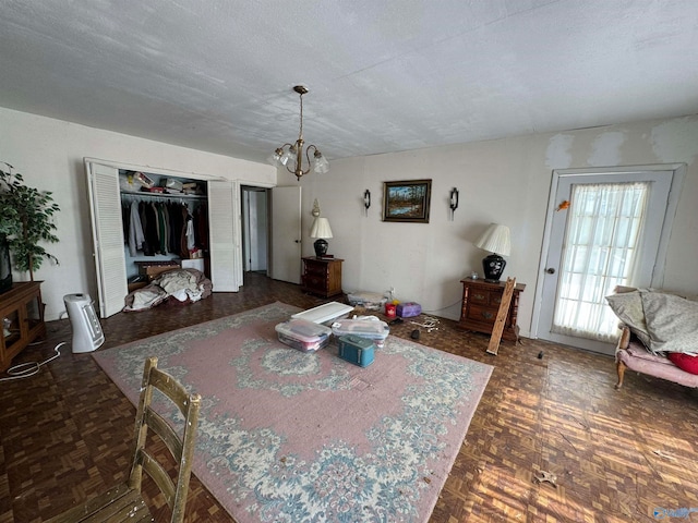 dining room featuring an inviting chandelier, dark parquet flooring, and a textured ceiling