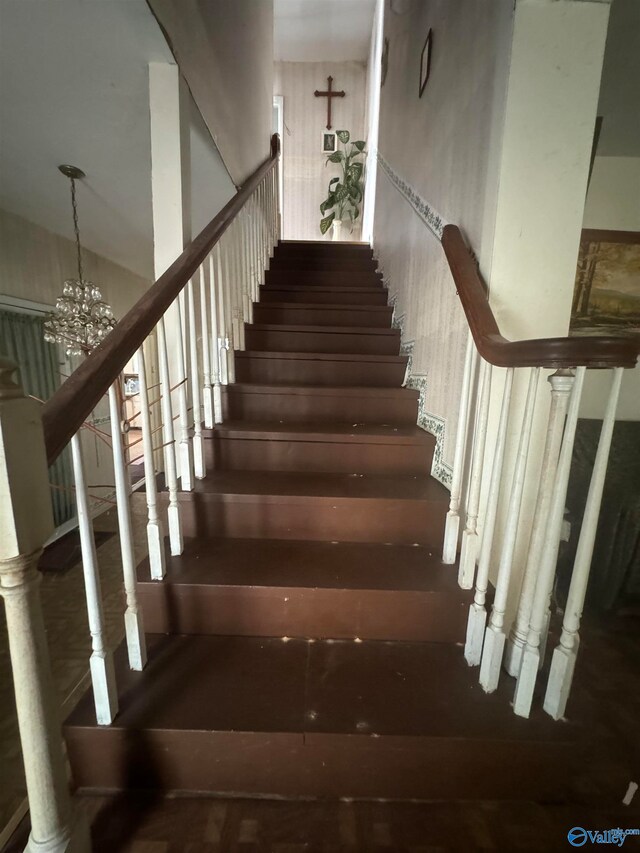 stairway featuring an inviting chandelier