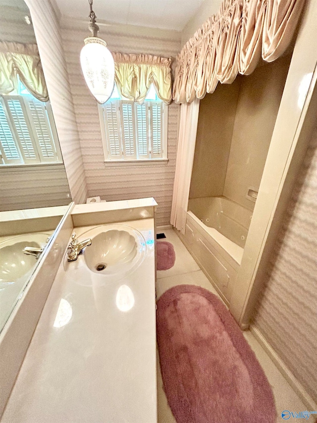 bathroom with tile patterned flooring, a tub, and vanity