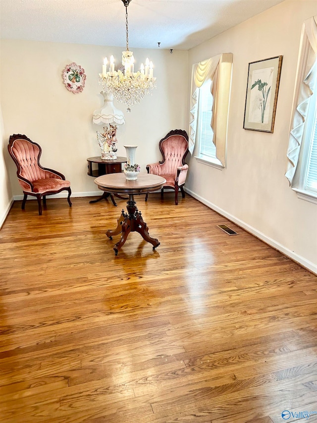 sitting room featuring light hardwood / wood-style flooring and a chandelier