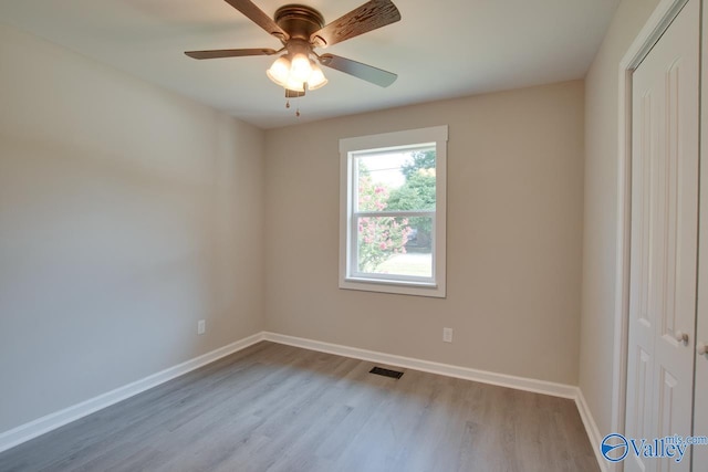 empty room with ceiling fan and light wood-type flooring