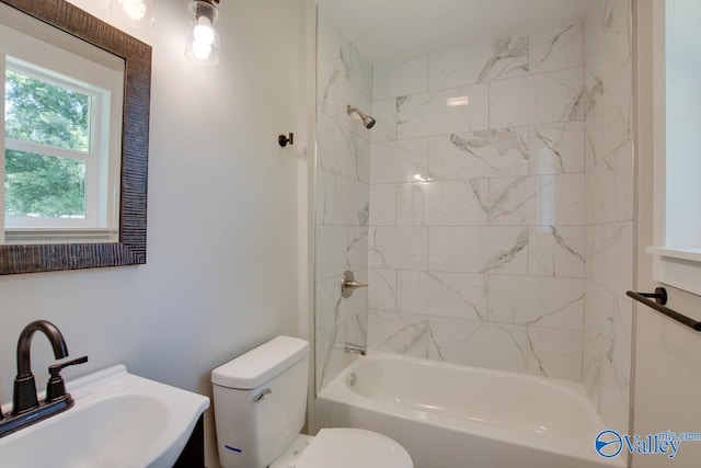 full bathroom with tiled shower / bath combo, sink, and toilet