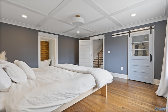 bedroom with hardwood / wood-style flooring, crown molding, a barn door, and coffered ceiling