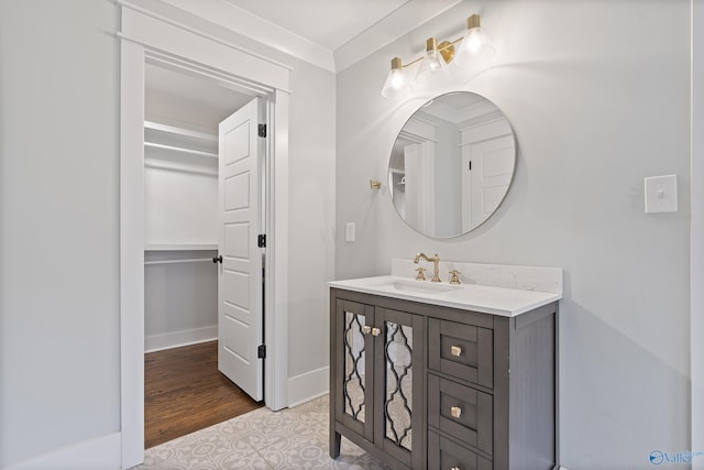 bathroom featuring vanity, hardwood / wood-style flooring, and crown molding