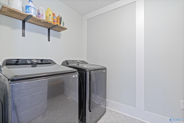 clothes washing area with light colored carpet and washing machine and dryer