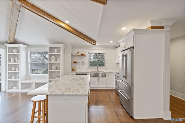 kitchen with white cabinetry, a kitchen island, sink, and plenty of natural light